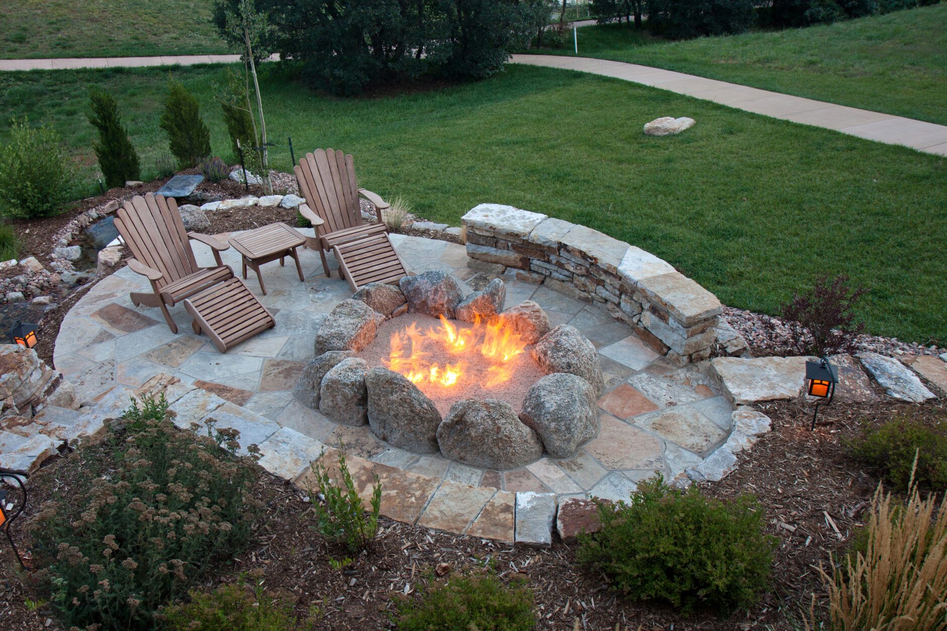 A cozy fire pit surrounded by hardscaping, showcasing a well-maintained outdoor space ready for winter. Lawn Care Bucks County